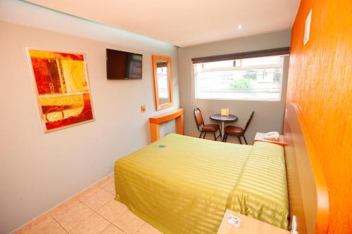 Un dormitorio con una cama y una mesa y una ventana. en Hotel Lira - Sólo Adultos, en Ciudad de México