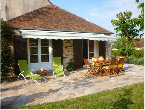 a patio with a wooden table and chairs at La roulotte de Pommette et Billy - Larès in La Hoguette