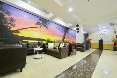 a lobby with couches and a palm tree mural at Mirage Suites de Boracay in Boracay