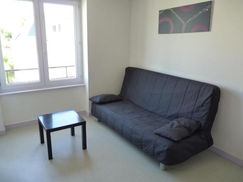 a blue couch in a living room with a table at Résidence Honoré de Balzac in Brest