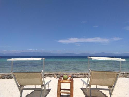 two chairs and a table on a beach at Ancelle Cristo Re in Moalboal