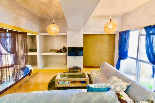 a living room with a couch and a table at Holiday Homes TSUBOYA 505 in Naha