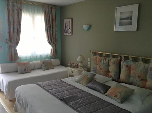 a bedroom with two beds and a window at Les Augustines in Quend