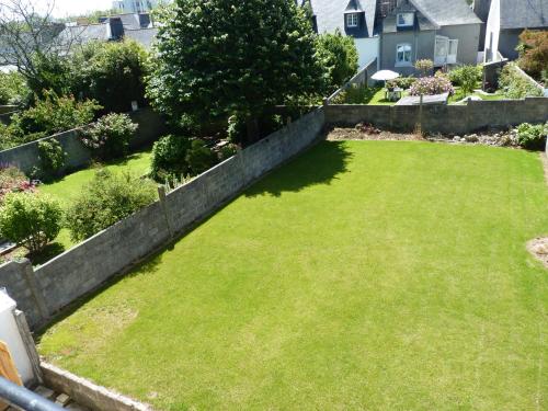 a yard with a retaining wall and green grass at Résidence Honoré de Balzac in Brest