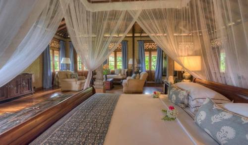 a bedroom with a large bed with curtains at Kahanda Kanda in Koggala