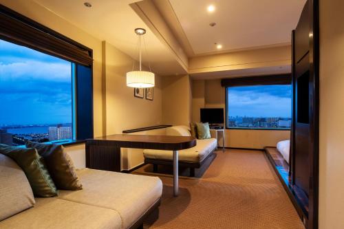 a hotel room with a desk and a large window at Urayasu Brighton Hotel Tokyo Bay in Urayasu