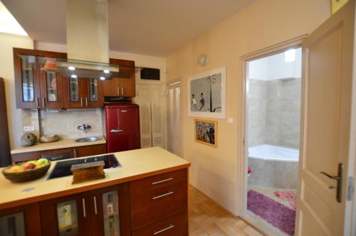 eine Küche mit Holzschränken und einem roten Kühlschrank in der Unterkunft Art Styles Boutique Apartment Szentendre in Szentendre
