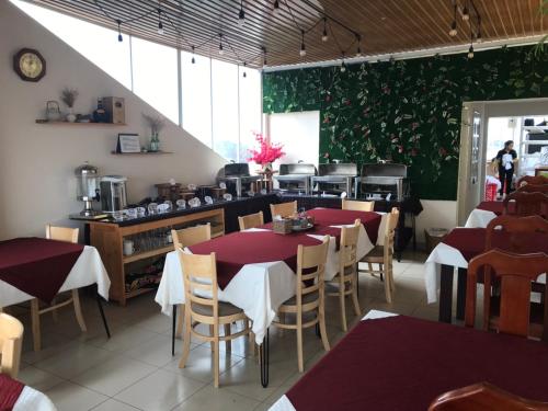 una sala ristorazione con tavoli e sedie rossi in un ristorante di Starhill Hotel a Da Lat