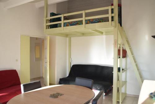 a living room with a bunk bed and a table at le lagon bleu - Fréjus in Fréjus