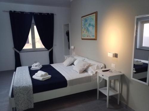 a bedroom with a bed and a table with towels on it at Cosmo Rooms a pochi passi da Tropea in Tropea