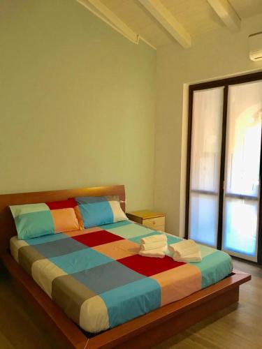 a colorful bed in a room with a window at CASA MADDALENA in Lierna