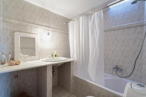 a bathroom with a tub and a sink and a shower at Marouso Villa Paros in Márpissa