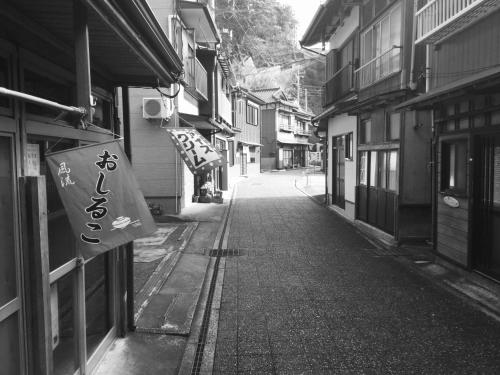 an alley with a sign on the side of a building at 島の宿 近 〜KON〜 in Oshima