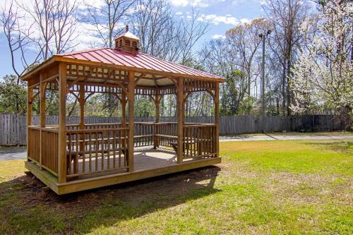 a wooden gazebo with a red roof in a yard at Auburn Lodge near University in Auburn