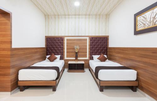Dos camas individuales en una habitación con ventana. en Ananyas Nest, en Coimbatore