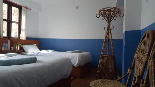 a room with two beds and a room with two chairs at Good Hotel in Bandīpur