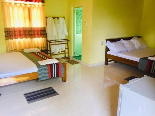 A bed or beds in a room at Suwani Pinnawala Homestay