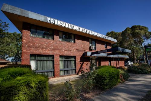 a red brick building with a sign on it at Parkside Inn Motel in Melbourne