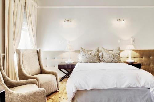 a bedroom with a bed and a chair at Banksia Boutique Hotel & Spa in Cape Town