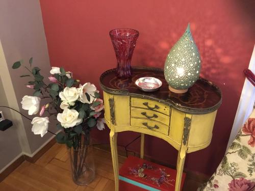 a yellow table with a vase and a glass at Athens-Plaka, Peter’s beautiful apartment in Temple of Zeus in Athens