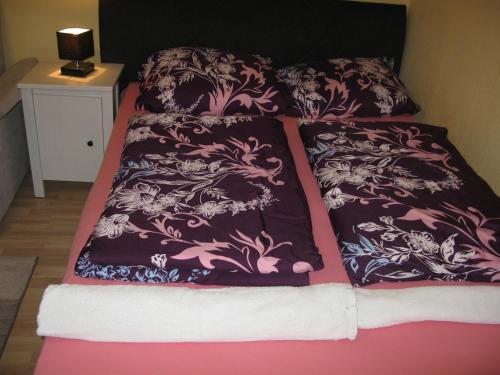 een bed met zwarte en roze dekens en kussens bij Comfortable Homly Apartment in Offenbach
