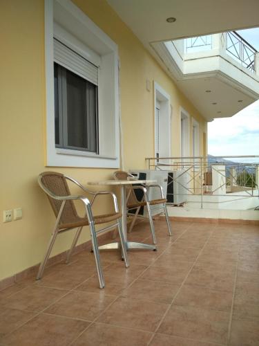 a room with a table and chairs on a balcony at Neochori hotel in Neochórion