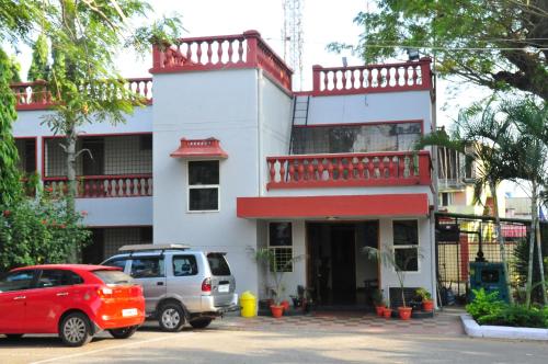a white building with cars parked in front of it at KSTDC Hotel Mayura Velapuri Belur in Belūr