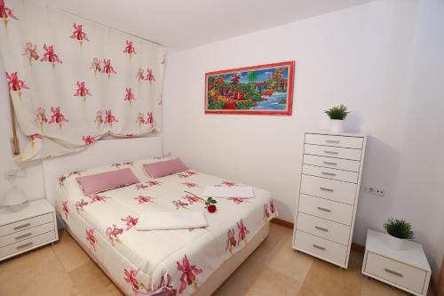 a small bedroom with a bed and a dresser at COSTA DAURADA APARTAMENTS - Zurbaran in Salou