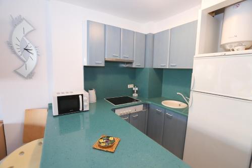 a kitchen with a blue counter top and a white refrigerator at COSTA DAURADA APARTAMENTS - Zurbaran in Salou
