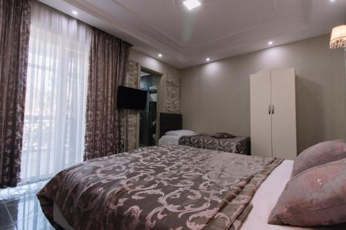 a bedroom with a large bed and a large window at Melrose House Hotel in Pamukkale