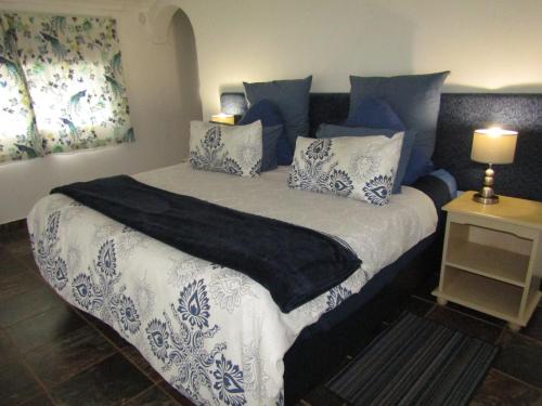 a bedroom with a large bed with blue and white pillows at Stone Hill in Magaliesburg