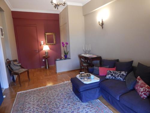 a living room with a blue couch and a rug at Athens-Plaka, Peter’s beautiful apartment in Temple of Zeus in Athens