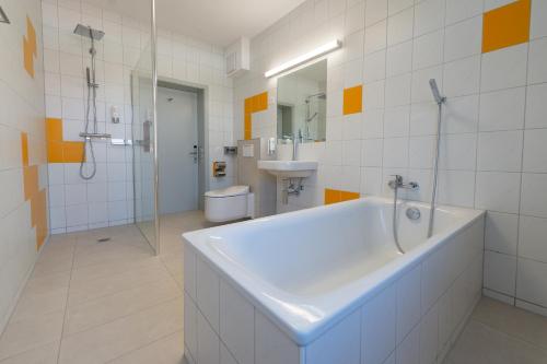 a bathroom with a tub and a toilet and a sink at Boutique Hotel BS16 before Bern City Parking gratis in Bern