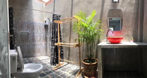 a bathroom with a shower and a toilet and a plant at Rim Lay in Ko Kood