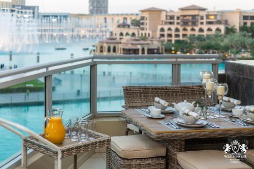 - une table sur un balcon avec vue sur l'eau dans l'établissement Westminster Burj Residences, à Dubaï