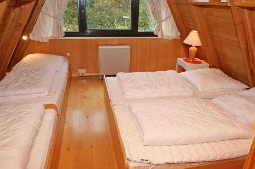 ダンプにあるgrosse sonnige Terrasse mit Markisのベッド2台、ランプ1台、テーブルが備わる客室です。