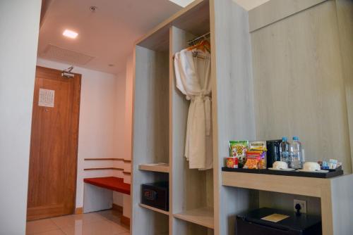 Zimmer mit einem Schrank und einem Bademantel auf einem Regal in der Unterkunft Ritz Grand Hotel Mandalay in Mandalay