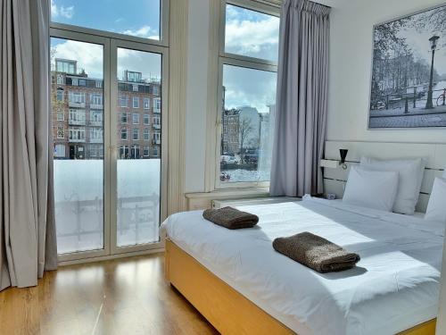 a bedroom with a large bed with two pillows on it at Jordaan View in Amsterdam