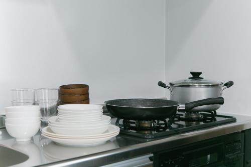 a stove with plates and a frying pan on it at Kourijima L'hotels in Nakijin