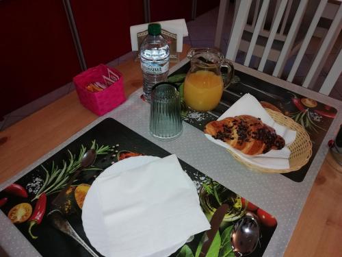a table with a tray of food and a glass of orange juice at B&B La casa dei frutti di bosco in Garlasco