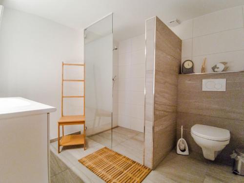 a bathroom with a toilet and a glass shower at Chalet Guttannen EG - GriwaRent AG in Guttannen