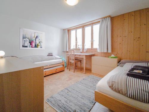 a bedroom with a bed and a desk and a table at Chalet Guttannen EG - GriwaRent AG in Guttannen