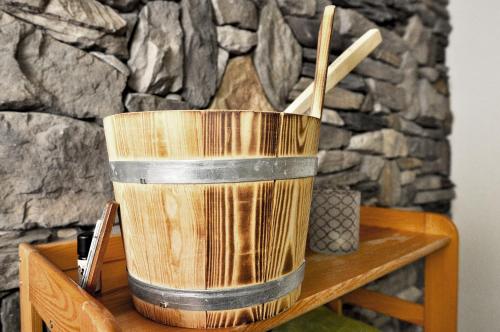 a wooden bucket sitting on a table with wooden sticks at Chalet Guttannen EG - GRIWA RENT AG in Guttannen