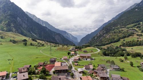 a village in a valley with mountains in the background at Chalet Guttannen EG - GRIWA RENT AG in Guttannen