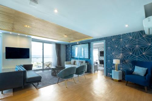 a living room with blue walls and blue chairs at Solea Mactan Resort in Mactan