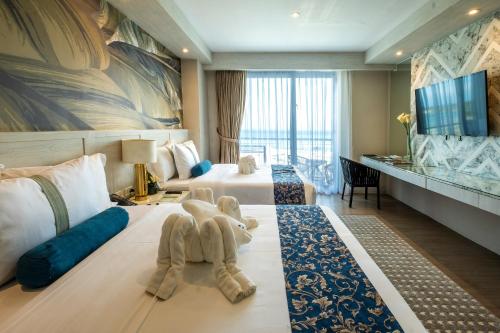 a hotel room with two beds with stuffed animals on it at Solea Mactan Resort in Mactan