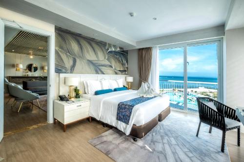 a hotel room with a bed and a view of the ocean at Solea Mactan Resort in Mactan