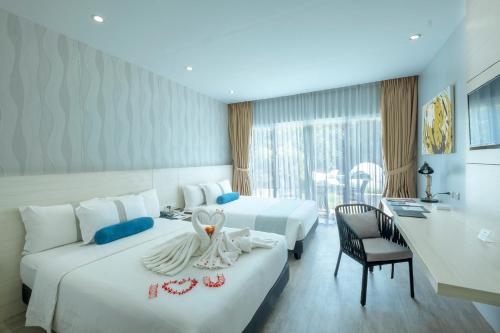 a hotel room with two beds and a desk at Solea Mactan Resort in Mactan