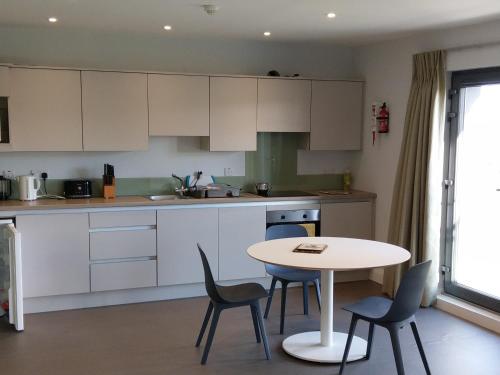 a kitchen with white cabinets and a table and chairs at Arbutus Lodge in Killarney