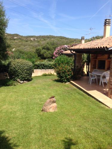 a yard with a house with a table and a patio at Case La Filetta in Santa Teresa Gallura